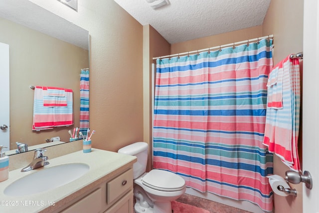 bathroom featuring a textured ceiling, a shower with shower curtain, vanity, and toilet