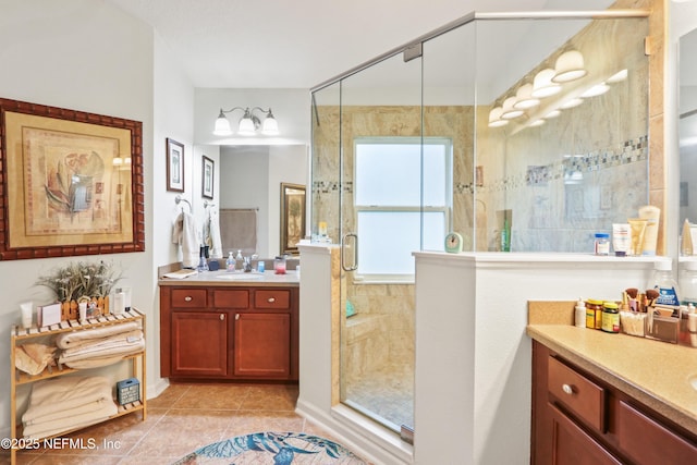 bathroom with tile patterned flooring, a shower with shower door, and vanity