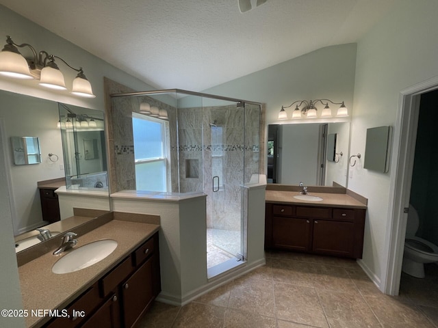 bathroom featuring toilet, a stall shower, a sink, and tile patterned floors