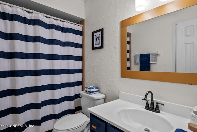 bathroom featuring vanity, toilet, and curtained shower