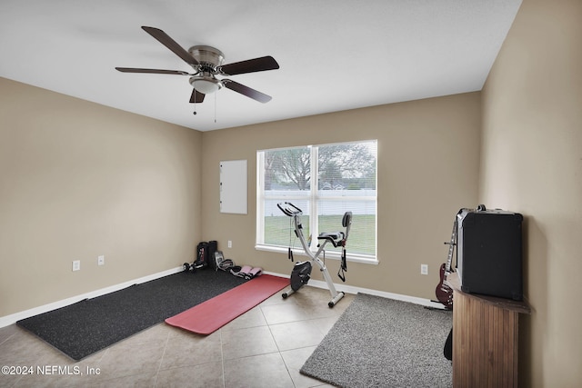 exercise room featuring light tile patterned floors and ceiling fan