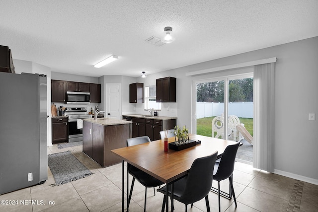 tiled dining area featuring a textured ceiling and sink