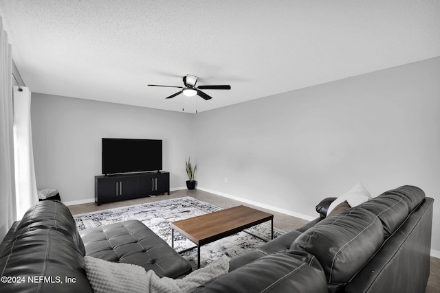 living room featuring ceiling fan and a textured ceiling