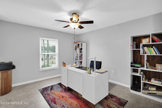 office area featuring ceiling fan, light tile patterned flooring, and a textured ceiling