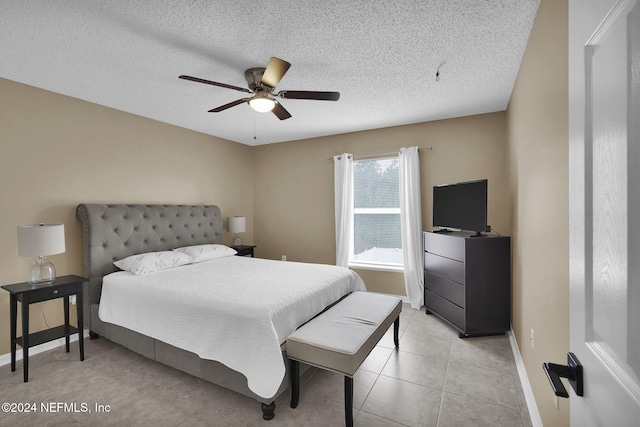 bedroom with a textured ceiling, ceiling fan, and light tile patterned flooring