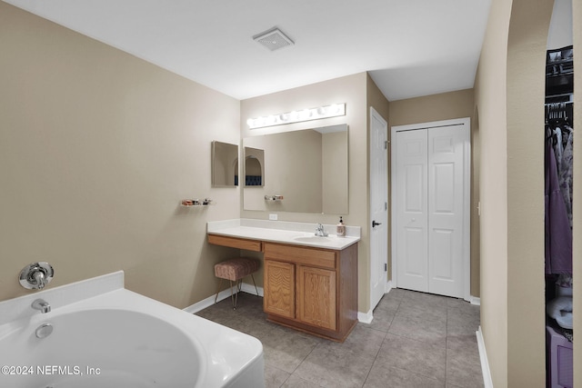 bathroom featuring tile patterned flooring, vanity, and a tub to relax in