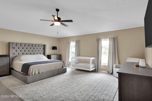 bedroom featuring ceiling fan and a textured ceiling