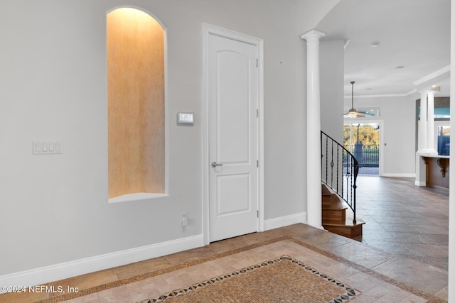 entrance foyer with ornate columns, ceiling fan, and crown molding