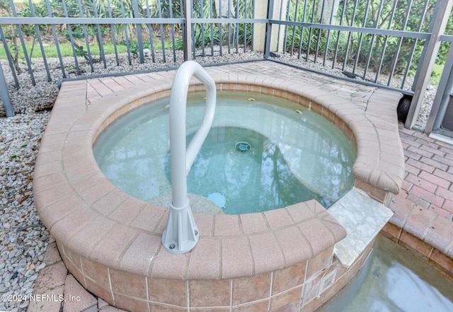 view of swimming pool featuring an in ground hot tub