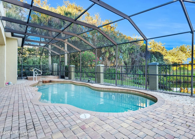 view of swimming pool with glass enclosure and a patio