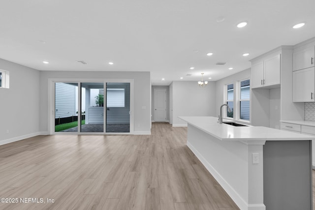 118 Caiden Dr, Ponte Vedra, FL 32081 - unfurnished living room featuring a sink, baseboards, recessed lighting, light wood-style floors, and a chandelier