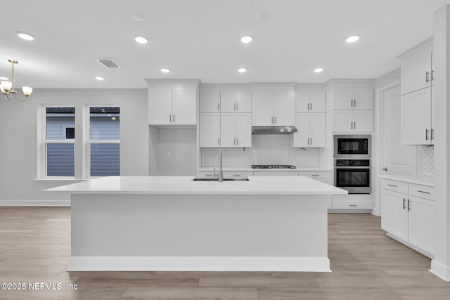 118 Caiden Dr, Ponte Vedra, FL 32081 - kitchen with black appliances, a sink, under cabinet range hood, decorative backsplash, and white cabinets