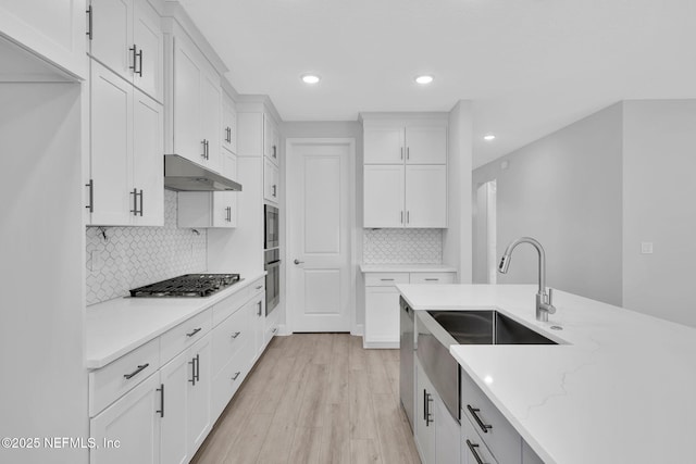 118 Caiden Dr, Ponte Vedra, FL 32081 - kitchen with white cabinetry, stainless steel gas stovetop, backsplash, a sink, and under cabinet range hood