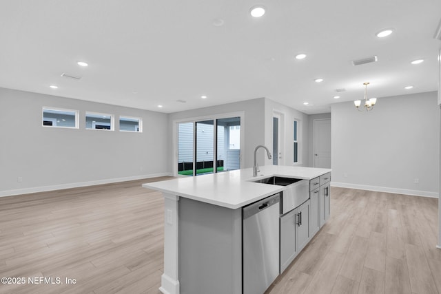 118 Caiden Dr, Ponte Vedra, FL 32081 - kitchen with stainless steel dishwasher, a sink, light wood-type flooring, light countertops, and baseboards