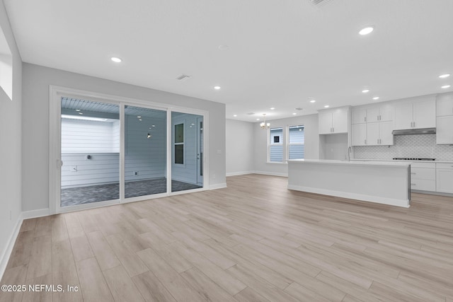118 Caiden Dr, Ponte Vedra, FL 32081 - unfurnished living room featuring light wood finished floors, baseboards, a sink, a chandelier, and recessed lighting