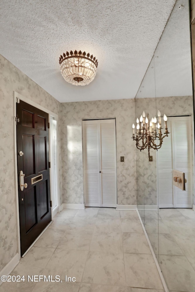 corridor with a chandelier and a textured ceiling