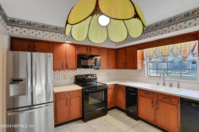 kitchen with sink, light tile patterned flooring, black appliances, and a textured ceiling