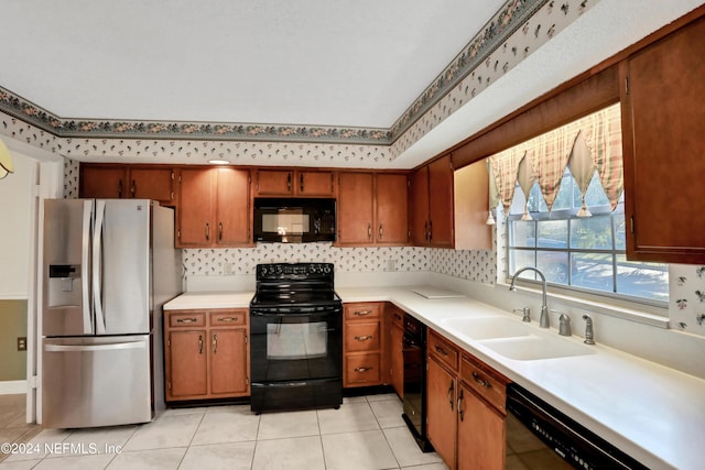 kitchen with black appliances, light tile patterned floors, and sink