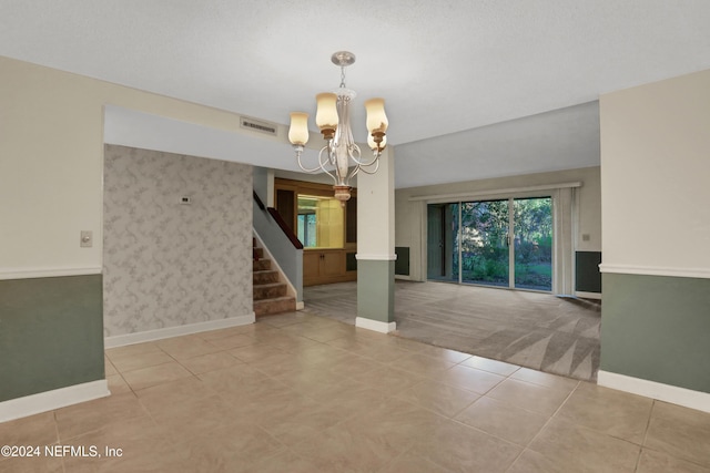 spare room featuring light tile patterned flooring and an inviting chandelier