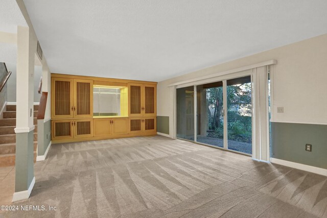 unfurnished living room with light colored carpet