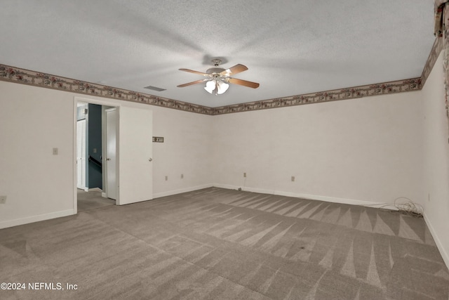 carpeted empty room featuring ceiling fan and a textured ceiling