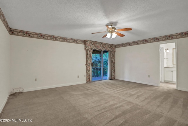 carpeted spare room with a textured ceiling and ceiling fan