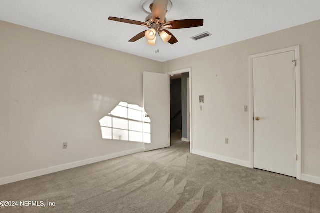 carpeted empty room featuring ceiling fan