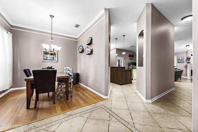 tiled dining space featuring a notable chandelier and crown molding