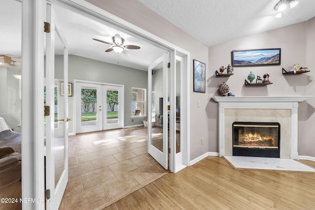 living room with lofted ceiling, a high end fireplace, french doors, and a textured ceiling