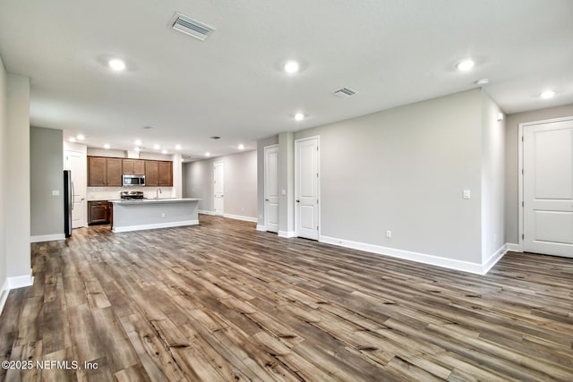 75484 Banyan Way, Yulee, FL 32097 - unfurnished living room featuring recessed lighting, dark wood-type flooring, baseboards, and a sink