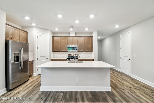 75484 Banyan Way, Yulee, FL 32097 - kitchen with stainless steel appliances, a sink, wood finished floors, backsplash, and recessed lighting