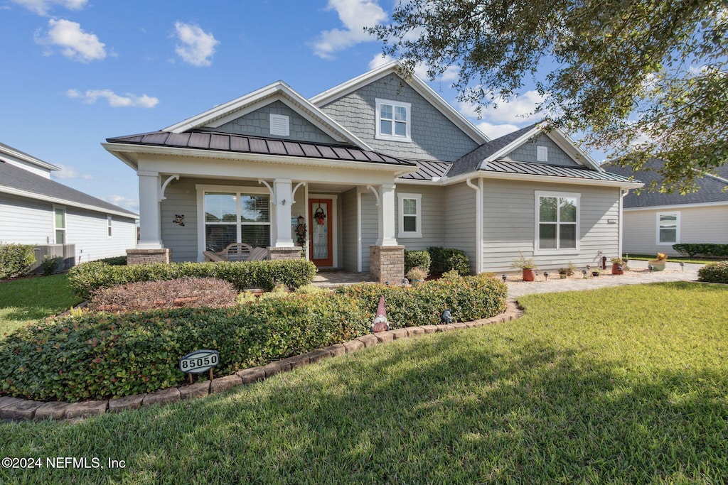 craftsman-style home with covered porch and a front yard