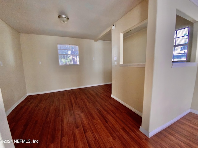 spare room with plenty of natural light and dark hardwood / wood-style floors