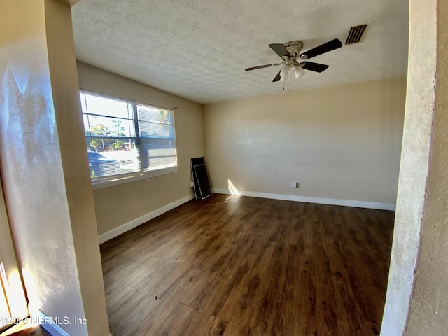 unfurnished living room featuring a textured ceiling, dark hardwood / wood-style flooring, and ceiling fan