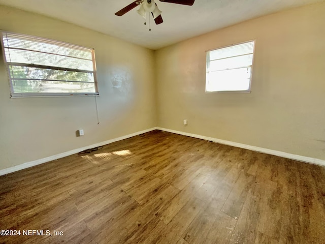 unfurnished room featuring hardwood / wood-style floors, plenty of natural light, and ceiling fan