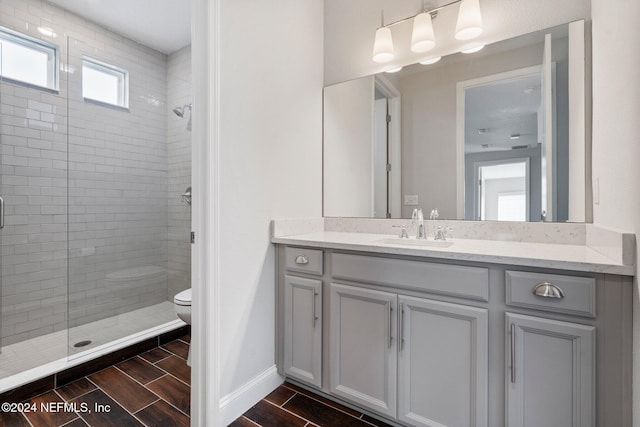 bathroom featuring vanity, toilet, and tiled shower