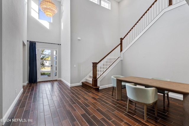 entrance foyer featuring dark hardwood / wood-style floors, a high ceiling, and an inviting chandelier