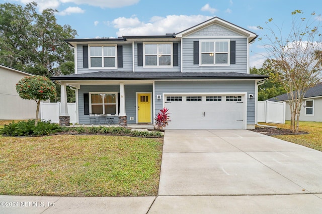 view of front of home with covered porch, a front yard, and a garage