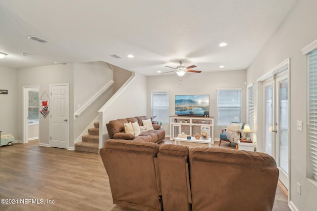 living room featuring light hardwood / wood-style flooring and ceiling fan