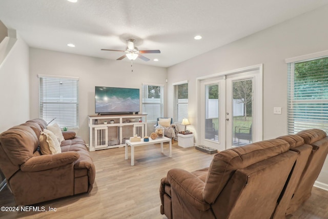 living room with ceiling fan, a healthy amount of sunlight, light hardwood / wood-style floors, and french doors