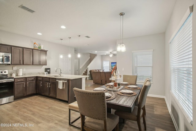 dining area featuring light hardwood / wood-style flooring, ceiling fan, and sink