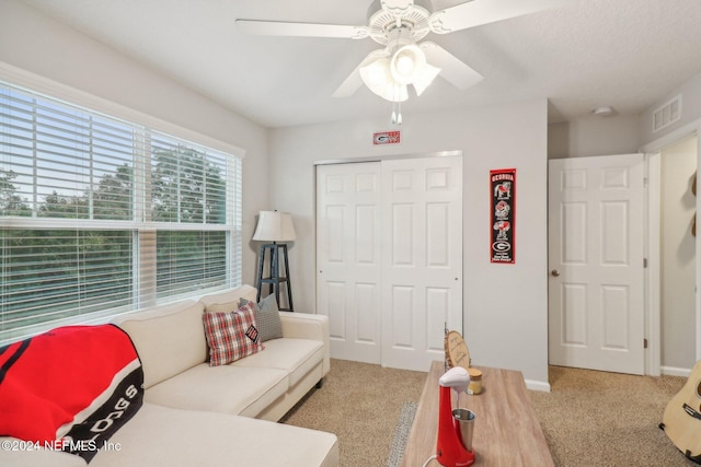 carpeted living room with ceiling fan