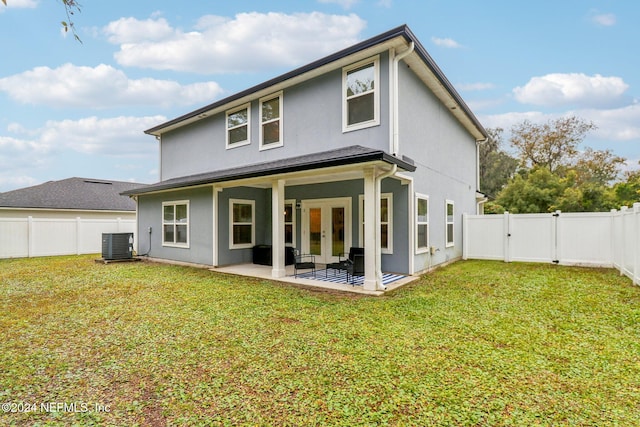 back of property with a patio, cooling unit, and a lawn