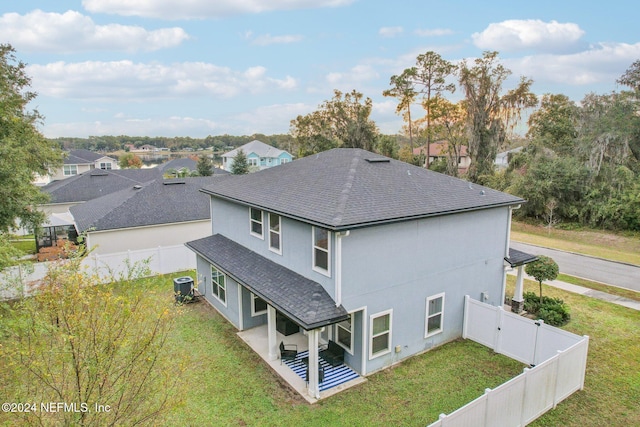 back of house with a yard, a patio, and central AC