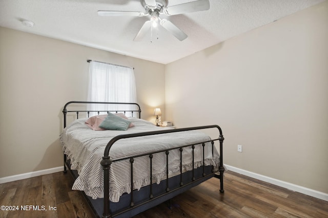 bedroom with ceiling fan, dark hardwood / wood-style flooring, and a textured ceiling