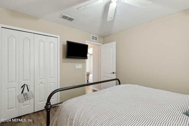 bedroom featuring a closet, ceiling fan, hardwood / wood-style floors, and a textured ceiling