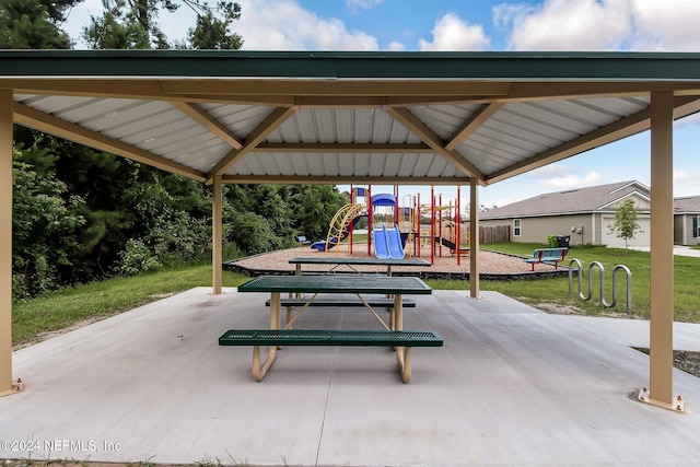 view of home's community with a lawn, a playground, and a patio