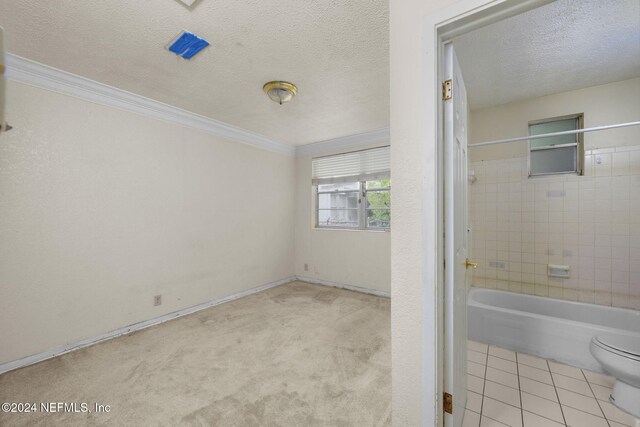 bathroom with tile patterned flooring, toilet, crown molding, and a textured ceiling