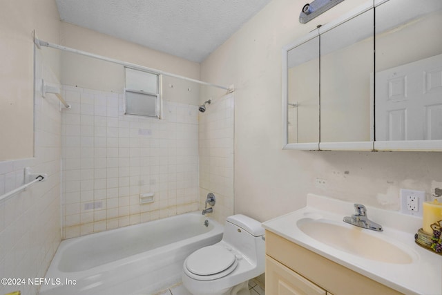 full bathroom with a textured ceiling, vanity, toilet, and tiled shower / bath