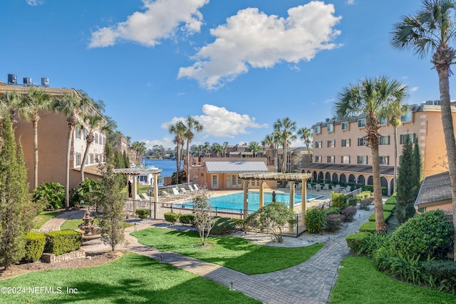 community pool featuring a pergola, a yard, and a water view